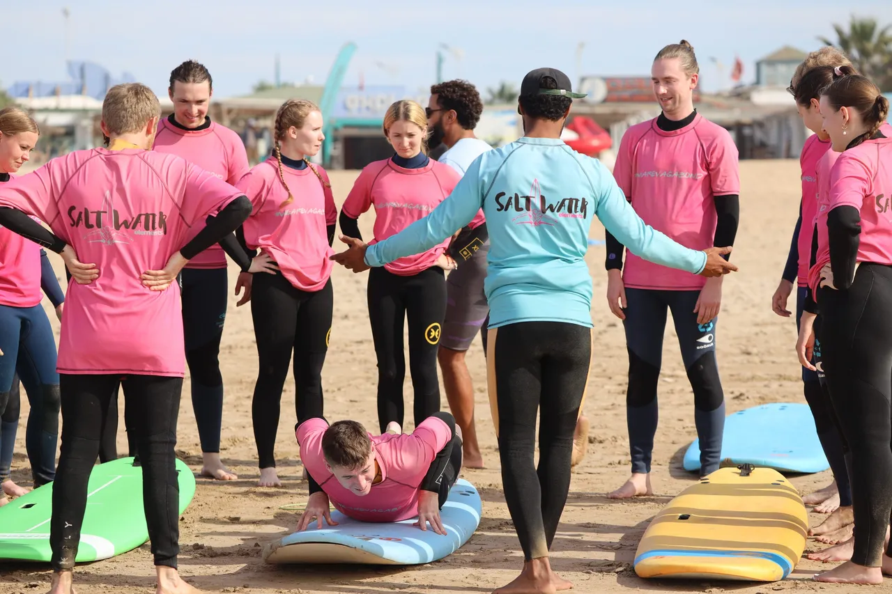 Échauffement sur la plage d'Essaouira avant un cours de surf