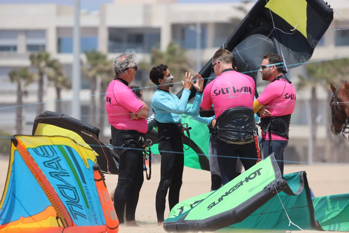 Groupe de kitesurfeurs qui préparent leurs ailes sur la plage d'Essaouira